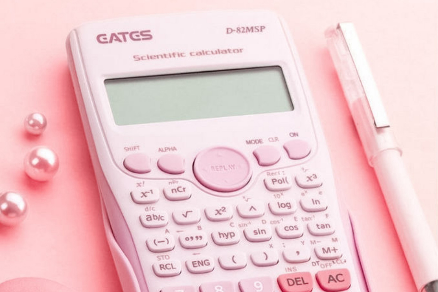 Pink calculator, macaroon and pen on a pink table.